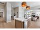 Kitchen with an island featuring a sink, stainless steel dishwasher, and views into the living area at 21663 N 57Th Ave, Glendale, AZ 85308