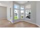 Light-filled living room with wood floors and scenic backyard views through expansive windows at 21663 N 57Th Ave, Glendale, AZ 85308