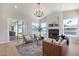 Cozy living room featuring a fireplace, sliding glass doors, and expansive water views from the windows at 21663 N 57Th Ave, Glendale, AZ 85308