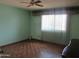 Inviting bedroom with parquet floors, ceiling fan, and natural light from the window at 2324 W Via Rialto Cir, Mesa, AZ 85202