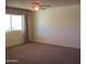 Inviting bedroom with neutral tones, large window, and cozy carpet, perfect for relaxation at 2324 W Via Rialto Cir, Mesa, AZ 85202