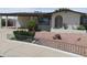 Quaint home featuring a low fence, desert landscaping, and an inviting front entrance with an arched portico at 2324 W Via Rialto Cir, Mesa, AZ 85202