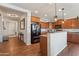 Modern kitchen offers stainless steel appliances, granite counters, and breakfast bar; connected to entry hall at 23637 W Hopi St, Buckeye, AZ 85326
