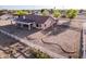 A rear overhead perspective displaying the home's solar panels, covered patio, landscaping and white fencing at 23717 N Mustang Way, Florence, AZ 85132