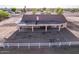 An elevated view of the home's backyard, featuring solar panels, covered patio and desert landscaping at 23717 N Mustang Way, Florence, AZ 85132
