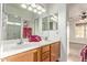 Bathroom featuring double sinks, wood cabinets, a large mirror, and modern lighting at 23717 N Mustang Way, Florence, AZ 85132