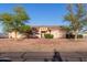 Single-story home with mature trees and brick lined walkway enhancing its curb appeal at 23717 N Mustang Way, Florence, AZ 85132