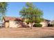 Charming single-story home featuring a well-maintained yard, mature tree and peach-colored exterior at 23717 N Mustang Way, Florence, AZ 85132