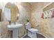 Stylish powder room featuring a pedestal sink, toilet, and attractive wallpaper at 23717 N Mustang Way, Florence, AZ 85132