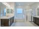 Luxurious bathroom featuring dual vanities, a soaking tub, and a glass-enclosed shower at 242 S 165Th Ave, Goodyear, AZ 85338