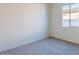 Cozy bedroom features plush carpeting and a bright window with a view of the property at 242 S 165Th Ave, Goodyear, AZ 85338