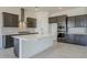 Well-equipped kitchen featuring dark cabinetry, a large island, and stainless steel appliances at 242 S 165Th Ave, Goodyear, AZ 85338