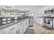 Bright kitchen featuring granite countertops, a stainless steel dishwasher, white cabinets, and a view to the outside at 2462 W Turtle Hill Dr, Anthem, AZ 85086