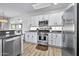Well-lit kitchen with stainless steel appliances, white cabinets, and granite countertops, providing a functional cooking space at 2462 W Turtle Hill Dr, Anthem, AZ 85086