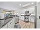 View of the sink and stainless appliances in kitchen with granite countertops, complemented by modern cabinetry and wood flooring at 2462 W Turtle Hill Dr, Anthem, AZ 85086