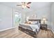 Comfortable bedroom features wood-look flooring, ceiling fan, and an ensuite bathroom visible through an open doorway at 2462 W Turtle Hill Dr, Anthem, AZ 85086