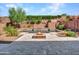 Inviting backyard oasis featuring a beautiful pool with a waterfall feature, a fire pit, and lush desert landscaping at 2462 W Turtle Hill Dr, Anthem, AZ 85086