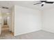 Neutral bedroom features neutral carpet, a ceiling fan, and an open hallway at 25087 W Dove Gap Dr, Buckeye, AZ 85326