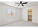 Well-lit bedroom with carpet, a ceiling fan, a closet, and a large window at 25087 W Dove Gap Dr, Buckeye, AZ 85326