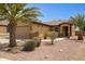 Attractive single-story home with desert landscaping, tile roof, and stone accents around the garage at 25087 W Dove Gap Dr, Buckeye, AZ 85326