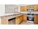 Practical kitchen features wood cabinetry, stainless steel dishwasher and oven, and neutral countertops at 25087 W Dove Gap Dr, Buckeye, AZ 85326