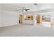 Open-concept living space featuring a ceiling fan and a view into the kitchen with breakfast bar at 25087 W Dove Gap Dr, Buckeye, AZ 85326
