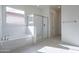Bright bathroom featuring a separate tub and glass-enclosed shower with white subway tile at 257 S 165Th Ave, Goodyear, AZ 85338