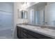 Bathroom features a double sink vanity with granite countertops and large mirror at 257 S 165Th Ave, Goodyear, AZ 85338