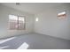 Sunlit bedroom with plush carpeting and backyard views through large picture windows at 257 S 165Th Ave, Goodyear, AZ 85338
