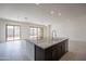 Kitchen island with granite countertops and dark cabinets, looking into living area with sliding glass doors at 257 S 165Th Ave, Goodyear, AZ 85338