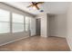 Bedroom with wood-look tile, neutral paint, and fan and light fixture at 2718 S Cupertino Dr, Gilbert, AZ 85295
