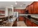 View of kitchen sink with stainless steel appliances and wooden cabinets and granite countertop at 2718 S Cupertino Dr, Gilbert, AZ 85295