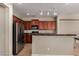 View of kitchen with stainless steel appliances and wooden cabinets and granite countertop at 2718 S Cupertino Dr, Gilbert, AZ 85295
