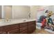 Bathroom with a double vanity, linen closet, and framed mirror above the sink at 2856 E Desert Broom Pl, Chandler, AZ 85286