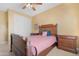 Bedroom features a wooden bed frame, tan walls, and a ceiling fan at 2856 E Desert Broom Pl, Chandler, AZ 85286