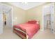 Bedroom featuring tan walls, a red bedspread, and access to a walk-in closet at 2856 E Desert Broom Pl, Chandler, AZ 85286