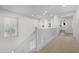 Hallway with white banister, neutral carpet, and natural light from the window at 2856 E Desert Broom Pl, Chandler, AZ 85286