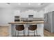 Bright kitchen features white cabinetry, an island with bar seating, and stainless steel appliances at 2856 E Desert Broom Pl, Chandler, AZ 85286