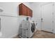 Bright laundry room with wooden cabinets, washer, dryer, and tiled floors at 2856 E Desert Broom Pl, Chandler, AZ 85286