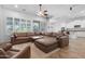 Open living room showcases a large leather sectional, natural light, and access to an open concept kitchen at 2856 E Desert Broom Pl, Chandler, AZ 85286