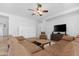 The spacious living room features a comfortable leather sectional, a ceiling fan, and a television at 2856 E Desert Broom Pl, Chandler, AZ 85286