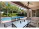 Covered patio with a dining table overlooking a sparkling pool and lush landscaping at 2856 E Desert Broom Pl, Chandler, AZ 85286