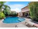 Stunning pool area surrounded by vibrant flowers, palm trees, and a meticulously landscaped yard at 2856 E Desert Broom Pl, Chandler, AZ 85286