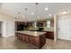 Modern kitchen featuring an island with a sink, granite counters, black appliances, and tile floors at 30617 N 138Th Way, Scottsdale, AZ 85262