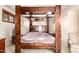 Spacious bedroom with wooden four-poster bed, window and sitting chair at 325 E Sharon Ave, Phoenix, AZ 85022