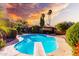 Stunning backyard pool with a diving board, lush tropical foliage, and a vibrant sunset sky at 325 E Sharon Ave, Phoenix, AZ 85022