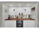 A modern coffee bar area with wine fridge, butcher block counters, white cabinets, and beverage serving station at 3445 E Pageant Pl, Gilbert, AZ 85297