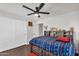 This bedroom features a ceiling fan, wood floors, and a closet with sliding doors at 3445 E Pageant Pl, Gilbert, AZ 85297