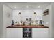 Stylish coffee bar features white cabinets, wood countertop, wine fridge and charming decor at 3445 E Pageant Pl, Gilbert, AZ 85297