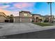 Elegant two-story home featuring a large driveway, a three-car garage, and a beautifully landscaped front yard with palm trees at 3445 E Pageant Pl, Gilbert, AZ 85297